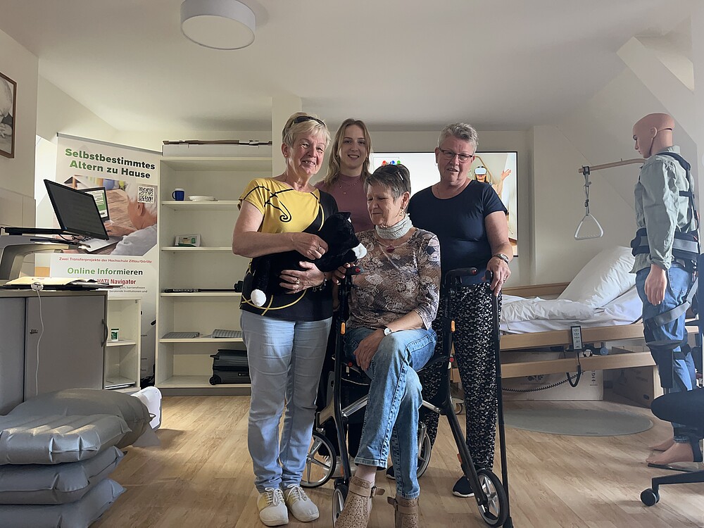 3 Damen im AAL-Labor mit verschiedenen Hilfsmitteln