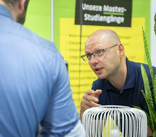 HSZG-Mitarbeiter im Gespräch mit einem Besucher.