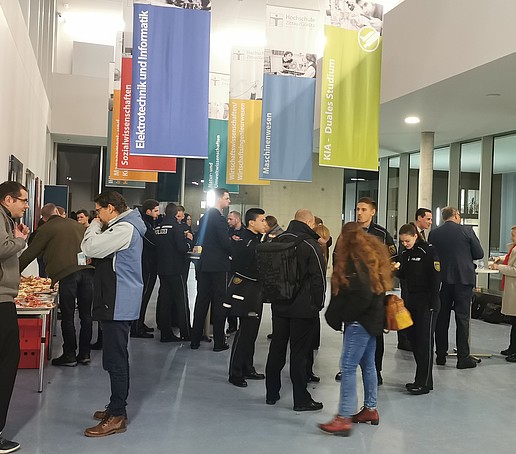 Come-Together im Foyer des Hörsaalgebäudes bei Getränken und Snacks.