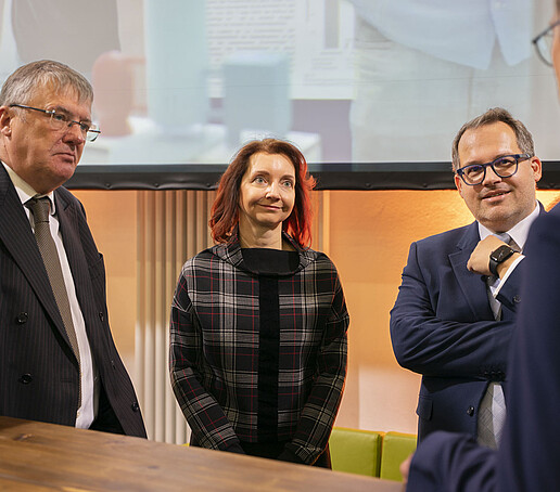 Prof. Hänsel, eine rothaarige Frau, der Rektor im Gespräch mit Prof. Kornhuber.