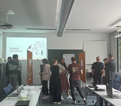 Teilnehmer stehen um Pinnwände und tauschen sich aus