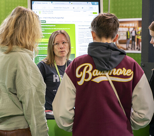 Die Studienberaterin berät eine Gruppe von drei Studieninteressierten.