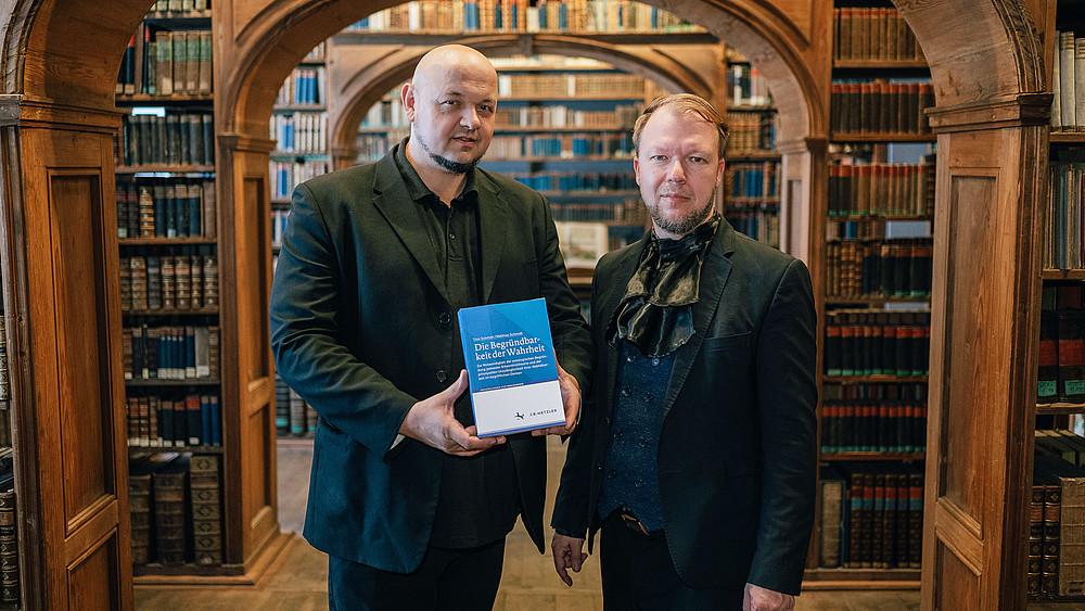 Prof. Matthias Schmidt und Tino Schmidt in einer Bibliothek.
