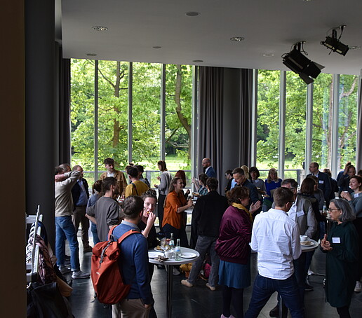 Große Gruppe an Stehtischen in der Aula