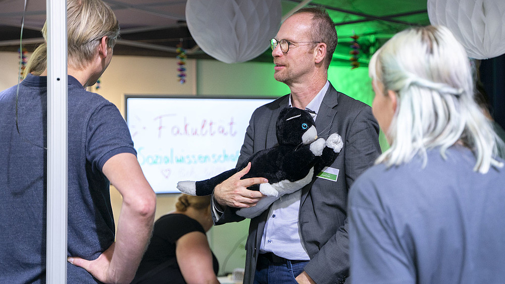 GAT-Institutsleiter Prof. Andreas Hoff hält die JustoCat im Arm auf dem Messestand beim INSIDERTREFF in Löbau.