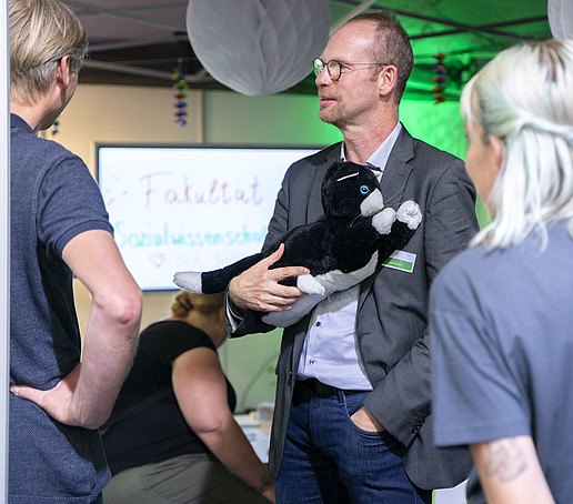 Prof. Hoff trägt die Demenzkatze im Arm.