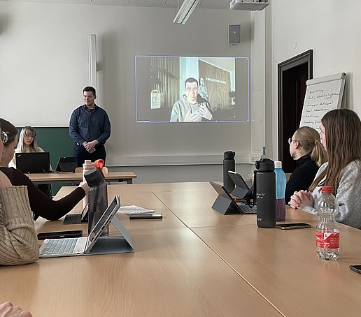 Studierende im Seminarraum lauschen einer Präsentation.