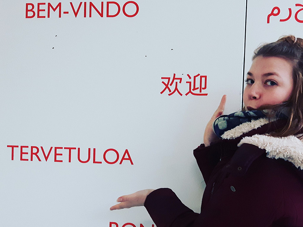 junge Frau zeigt auf Wand