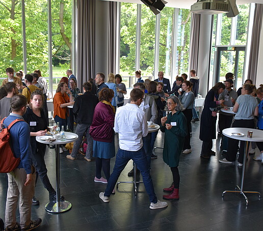 Große Gruppe an Stehtischen in der Aula