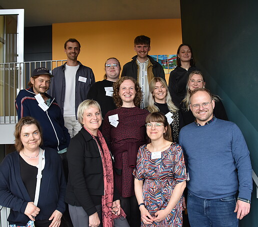 Gruppe von Mitarbeitern posiert auf der Treppe