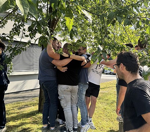 Studierende stehen um einen Baum.