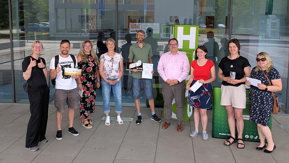 Der Rektor, Vertreter vom Gesundheitsmanagement der Hochschule und Teilnehmende stehen zum Gruppenfoto nebeneinander vor Haus vier.