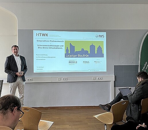 Tilo Saßbach hält einen Vortrag vor Publikum im Seminarraum.