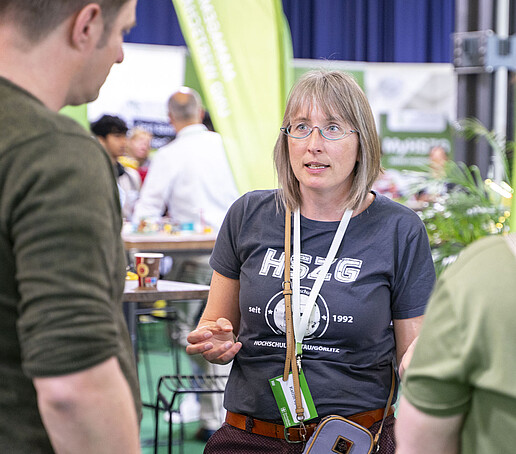 Eine Mitarbeiterin berät zwei Besucher.