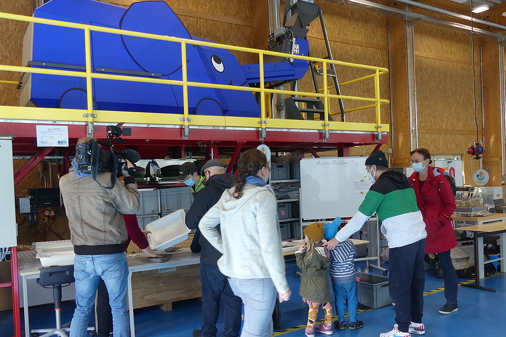 Besucher*innen bestaunen die Sortieranlage, die als kleiner Blauer Elefant verkleidet ist.