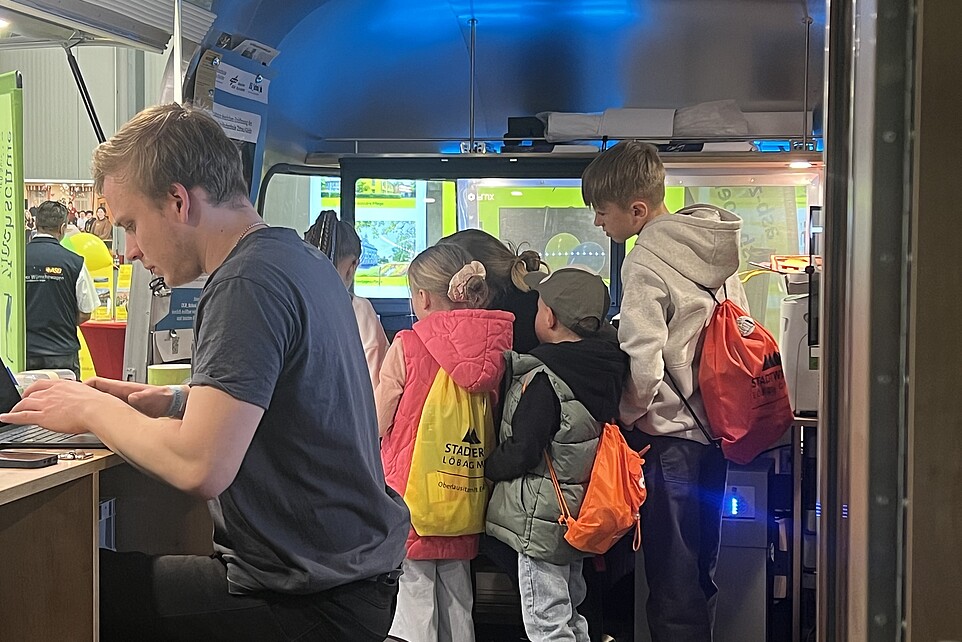 Kinder im Bus versammeln sich um den Laser-Cutter.