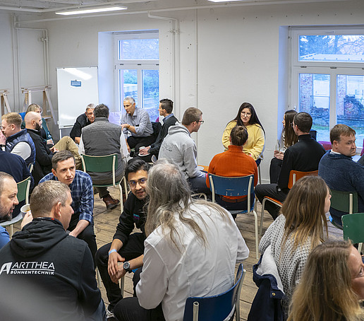 Ein Saal voller Workshopteilnehmenden in Diskussion.