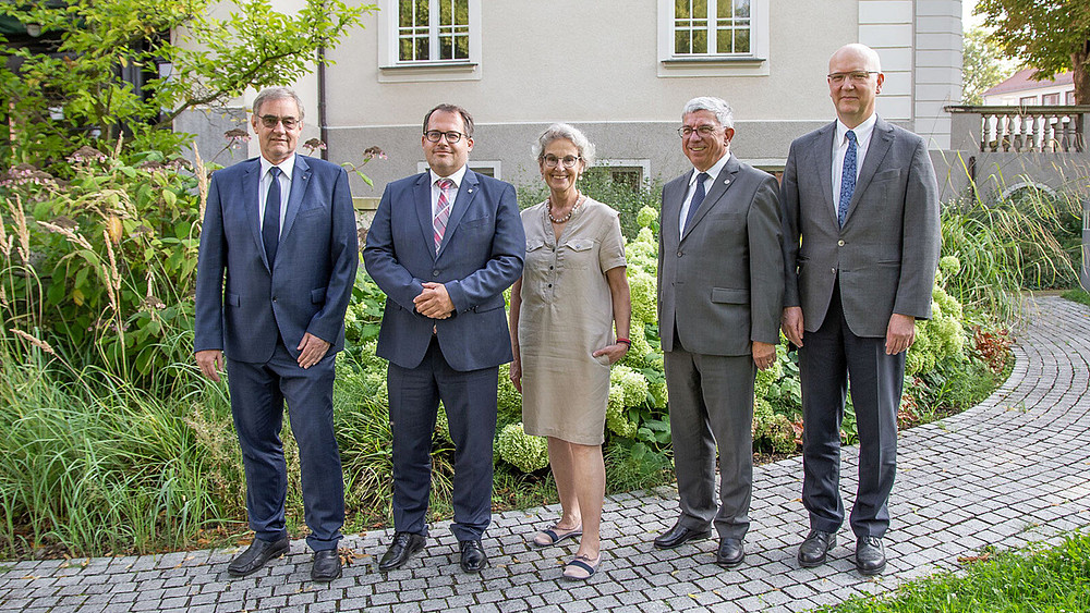 Prof. Uwe Götze, Prorektor für Transfer und Weiterbildung der TU Chemnitz (l.), Prof. Alexander Kratzsch, Rektor der Hochschule Zittau/Görlitz (2.v.l.), Prof. Ursula M. Staudinger, Rektorin der TU Dresden (Mitte), Prof. Klaus-Dieter Barbknecht, Rektor der TU Bergakademie Freiberg (2.v.r) und CircEcon-Geschäftsführer Prof. Niels Modler, TU Dresden (r.), trafen sich zur konstituierenden Sitzung des Lenkungsausschusses für CircEcon am 16. August an der TU Dresden. Sie stehen im Garten vor einem grauen Gebäude.