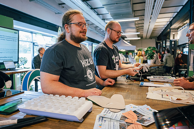 GAT-Mitarbeiter stehen am Stand des AAL-Labors