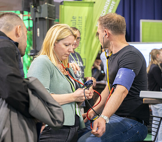 Ein Besucher lässt sich seinen Blutdruck messen.