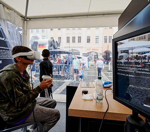 Ein Junge probiert eine VR-Brille aus.