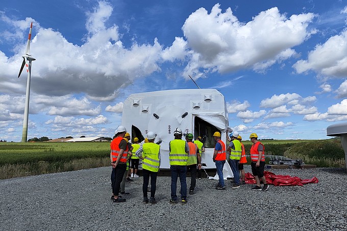 Eine Gruppe von Menschen mit auf einem Feld an einem Baufahrzeug