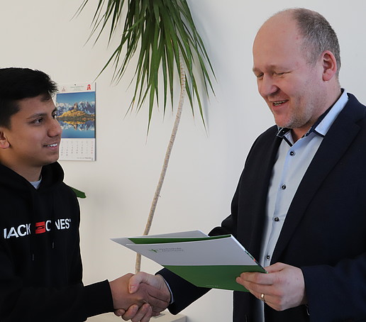 Samir Bishwokarma erhält die Urkunde aus den Händen von Dezernent RD Christoph Duscha.