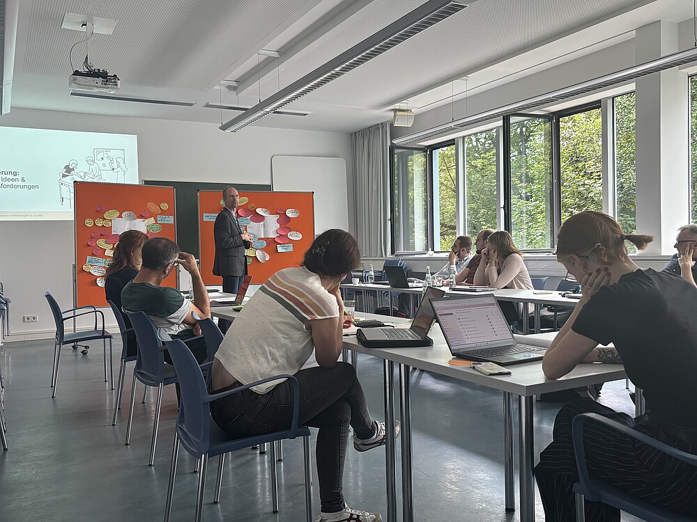mehrere Menschen im Seminarraum