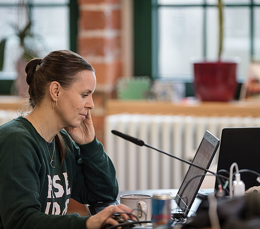 Mitarbeiterin schaut auf den Laptopbildschirm