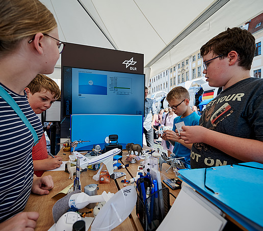 Kinder informieren sich am DLR-Stand.