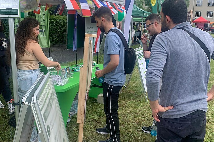 Festteilnehmende unterhalten sich rund um den International Pavillon.