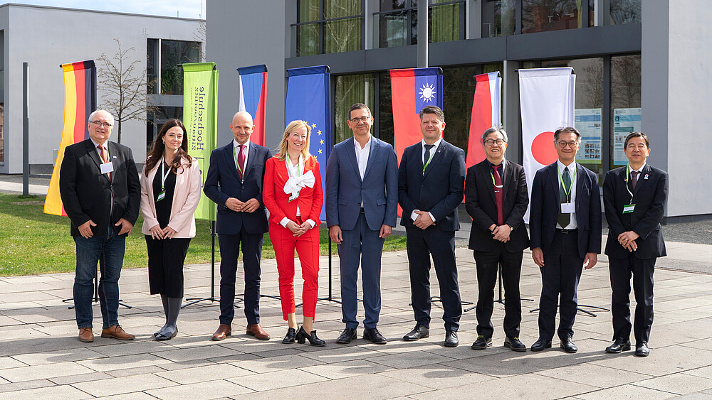Gruppenfoto vor dem Gebäude der Hochschule Zittau/Görlitz mit zehn Personen vor internationalen Flaggen. Abgebildet von links nach rechts: Miroslav Brzezina, Kateřina Maršíková, Stephan Meyer, Sophia Keil, Christian Koitzsch, Thomas Zenker, Jhy-Wey Shieh, Lian-Ruey Ke, Kunihiko Kawazu.