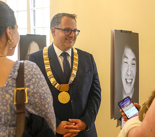 Der Rektor ist im Gespräch mit seinen Gästen im Foyer neben dem Ratssaal.