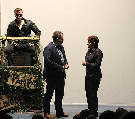 Rektor und Kanzlerin auf der Bühne. Im Hintergrund sitzt der Terminator.