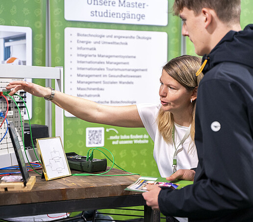 Eine HSZG-Mitarbeiterin erklärt einer Besucherin ein Exponat.