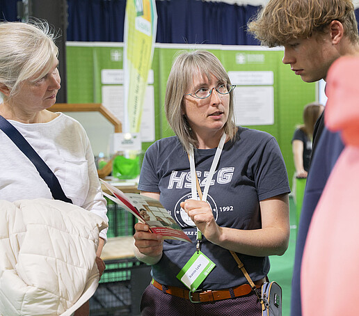Eine Mitarbeiterin berät Besucher.