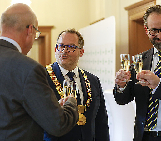 Rektor, Prof. Drossel, Herr Gemkow und Herr Zenker stoßen mit Sektgläsern an.