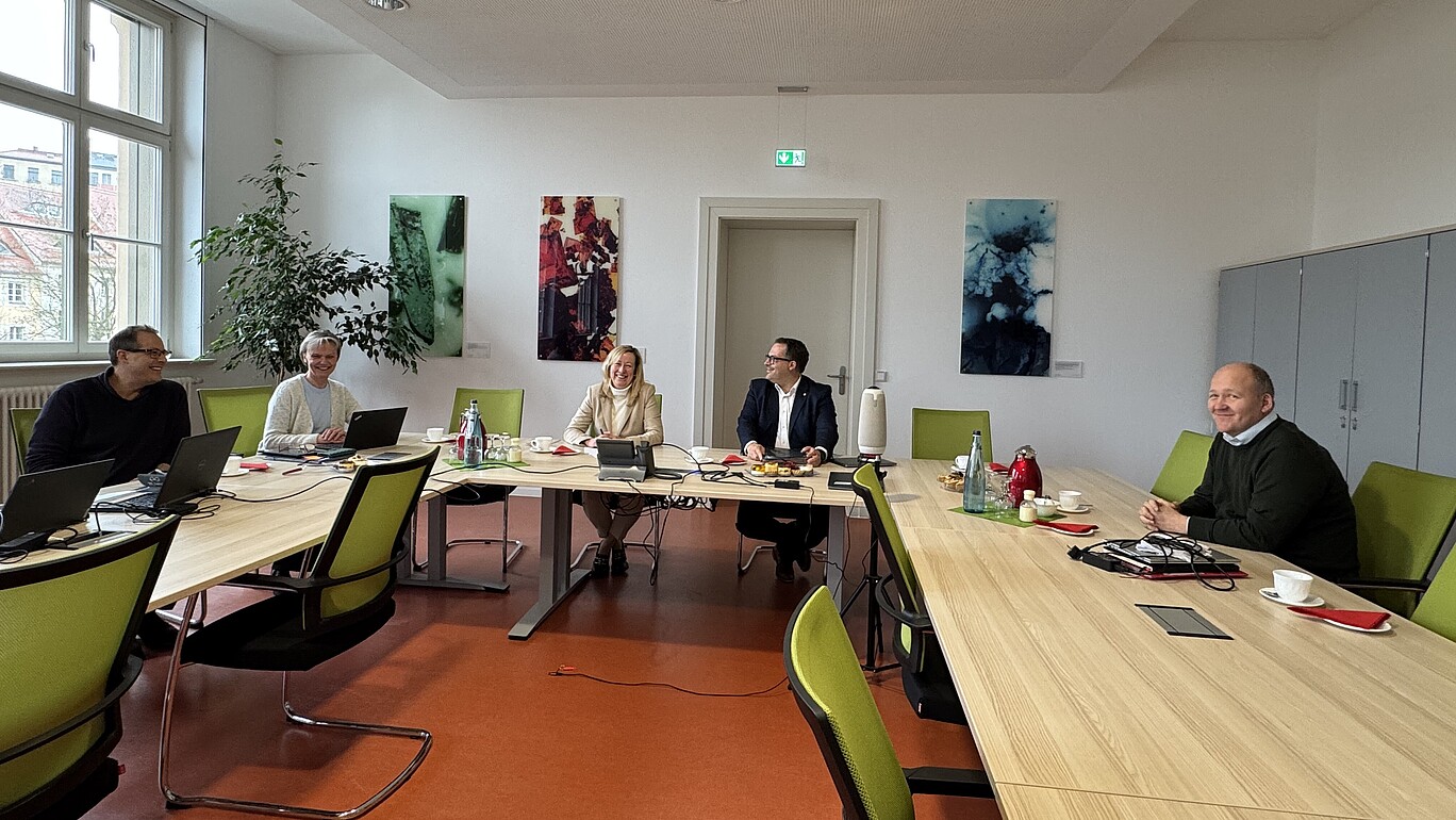 Das Rektorat und der Referent des Rektors sitzen an den Tischen im Senatssaal.