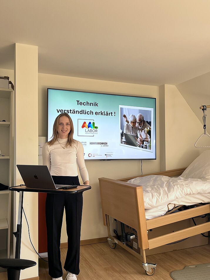 Referentin mit Laptop vor großem Bildschirm