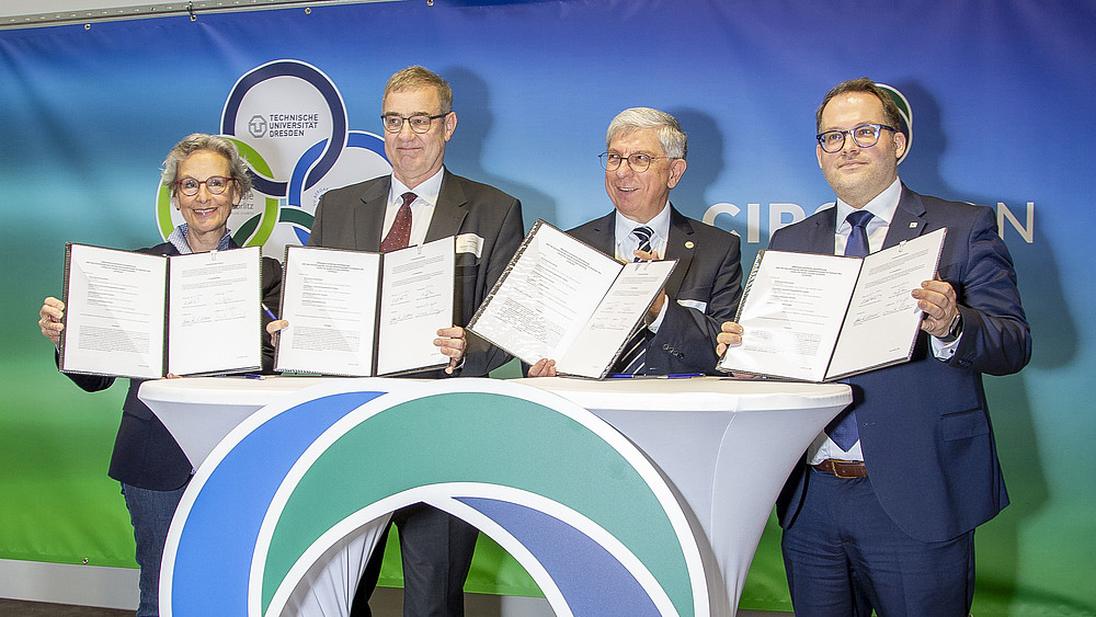 Prof.in Ursula Staudinger, Rektorin der TU Dresden, Prof. Uwe Götze, Prorektor für Transfer und Weiterbildung der TU Chemnitz, Prof. Klaus-Dieter Barbknecht, Rektor der TU Bergakademie Freiberg sowie der Rektor der Hochschule Zittau/Görlitz Prof. Alexander Kratzsch halten die unterzeichneten Kooperationsverträge in die Höhe.