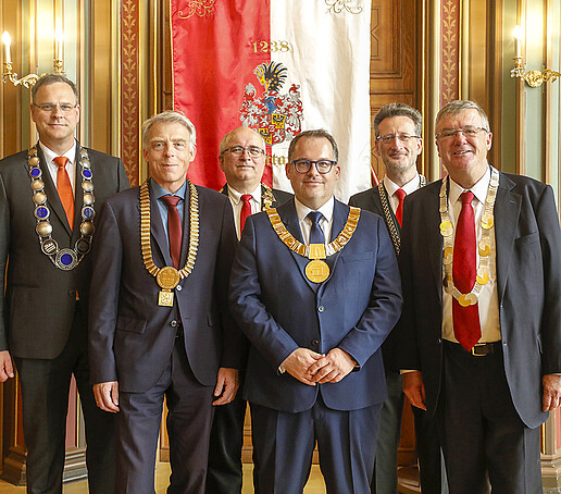 Die Rektoren der Sächsischen HAW stehen im Bürgersaal nebeneinander und lächeln in die Kamera.