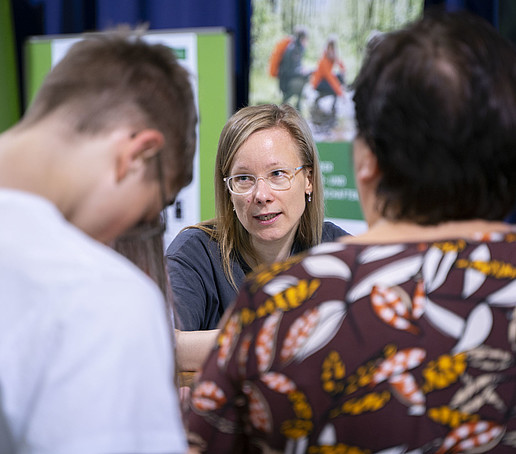 Die Studienberaterin im Gespräch mit zwei Besuchenden.