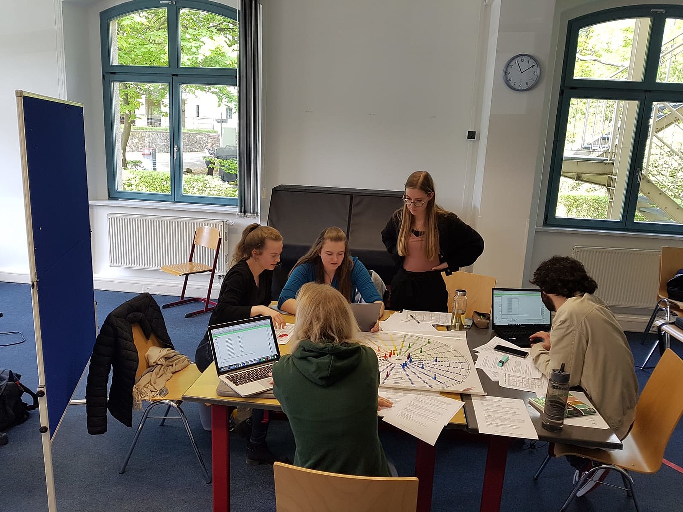 Studierende sitzen um ein Brettspiel