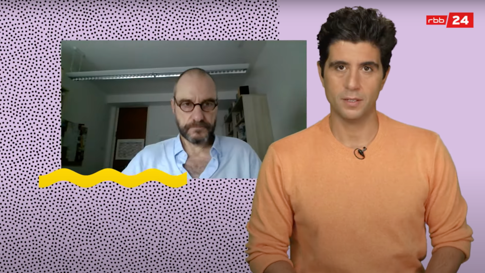 Prof. Kollmorgen und ein Moderator unterhalten sich. Der Prof. ist aus seinem Büro dazugeschaltet.