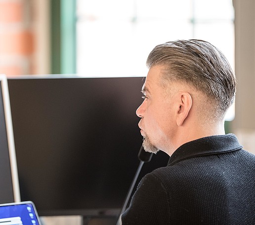HSZG-Mitarbeiter vor seinem Laptopbildschirm im Technikraum
