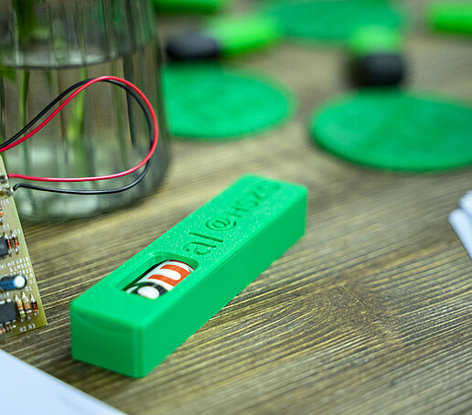 Eine grüne Kunststoffschachtel liegt auf einem Tisch.