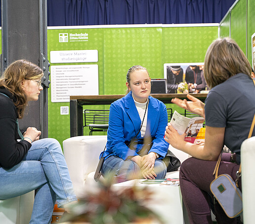 Auf weißen Sofas sitzen Schülerinnen und lassen sich über das Lehramt-Studium beraten.