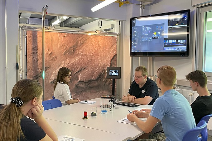 Versuchsteilnehmende sitzen am Tisch.