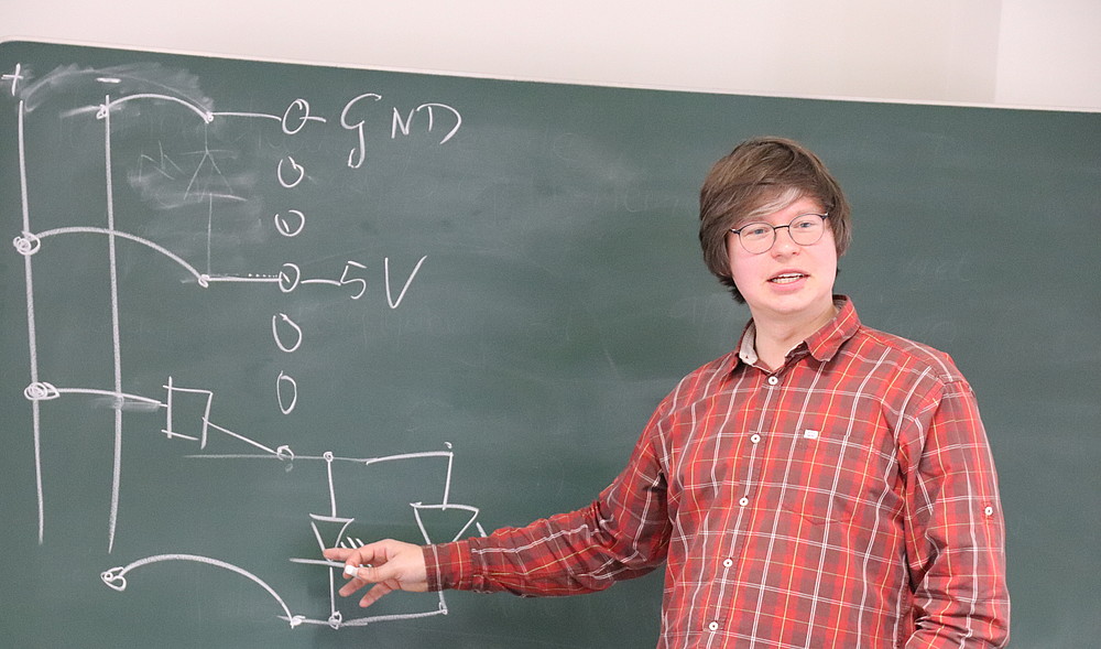 Randolf Rotta erklärt, wie auf der Steckplatte ein einfacher Stromkreis hergestellt werden kann.