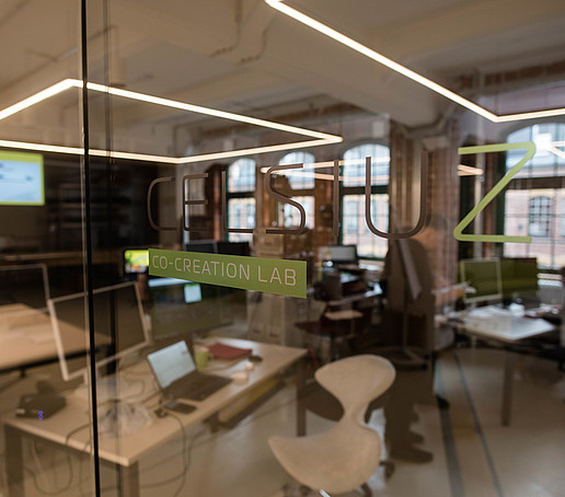 Blick durch die Glastür mit Celsiuz-Aufschrift in den Übertragungs- und Tontechnikraum